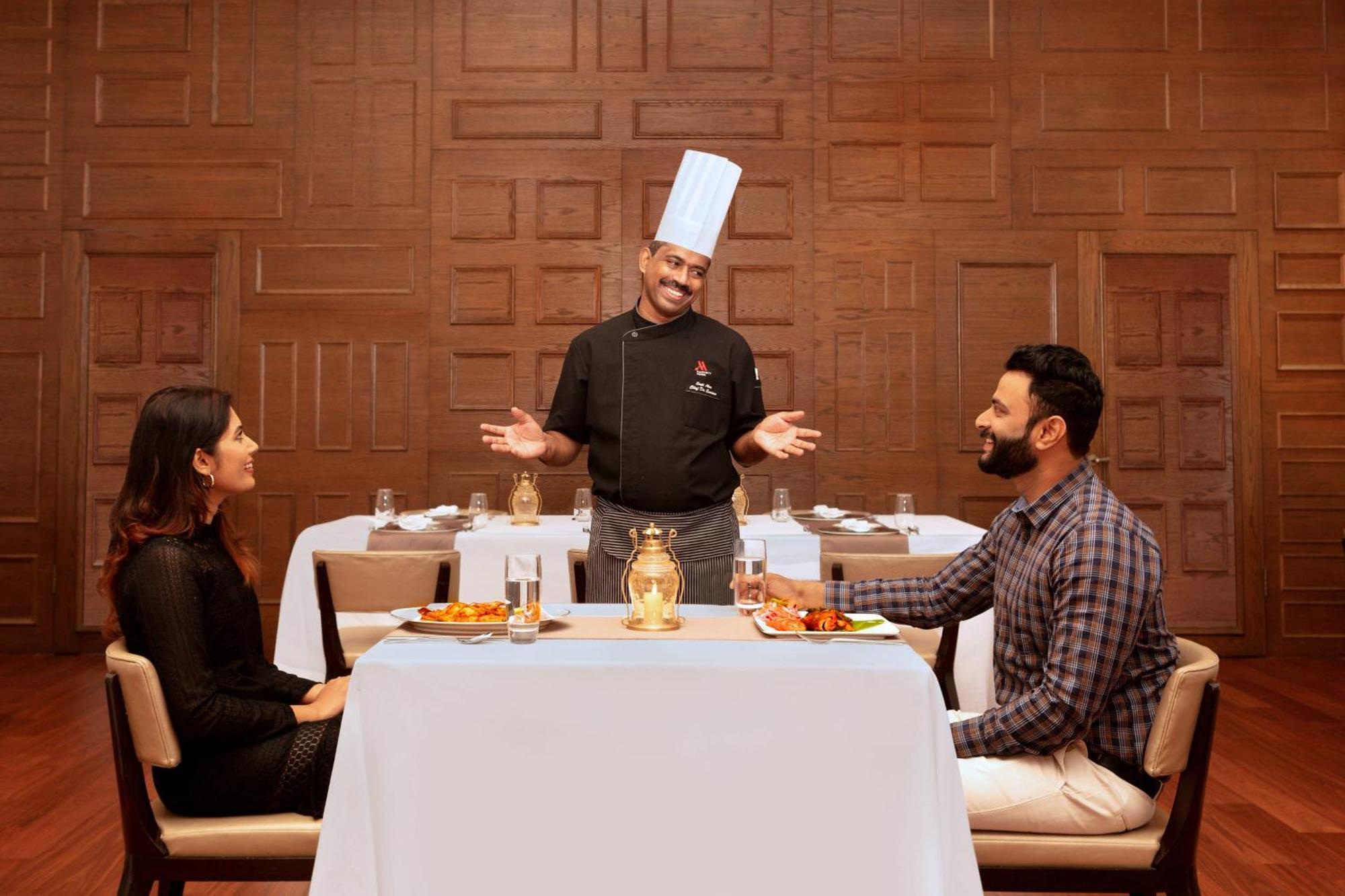 Kochi Marriott Hotel Экстерьер фото A chef serving food to guests